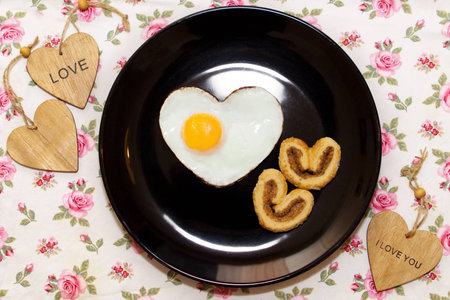 Composition of the biscuits and eggs in a heart shape and wooden hearts. Valentine's Dayの写真素材