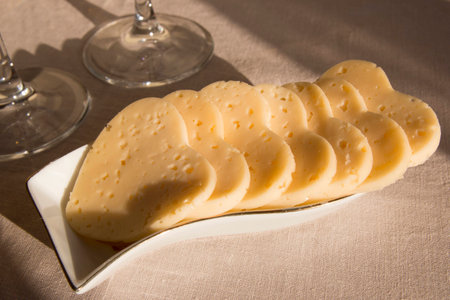 Heart shaped cheese in a white plate and two glasses. Valentine's Day の写真素材