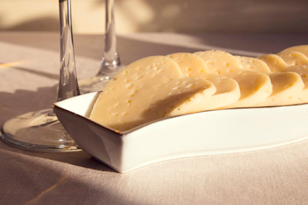 Heart shaped cheese in a white plate and two glasses. Valentine's Dayの写真素材