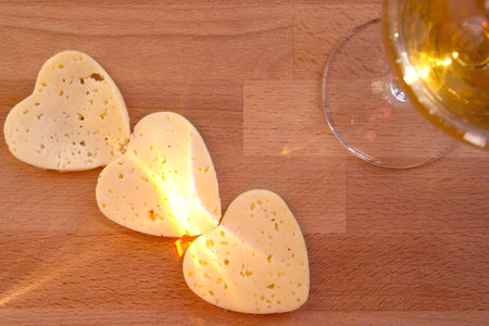 Heart shaped cheese and a glass of white wine. Valentine's Dayの写真素材
