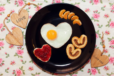 Breakfast with biscuits, sandwich with jam, and scrambled egg in a heart shape. Valentine's Dayの写真素材