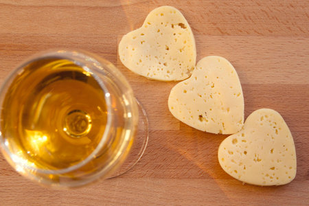 Heart shaped cheese and a glass of white wine. Valentine's Dayの写真素材