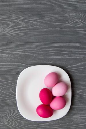 Pink colored eggs on a white plate on a gray table. Easter celebrationの写真素材