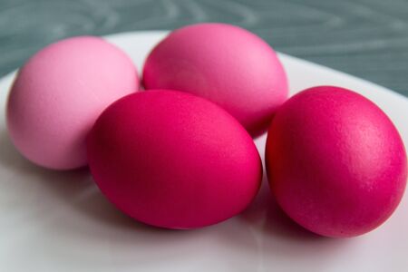 Pink colored eggs on a white plate on a gray table. Easter celebrationの写真素材