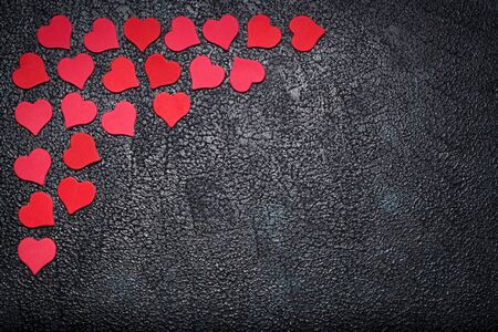 Red paper hearts on dark background with space for text. Concept of romantic loveの写真素材