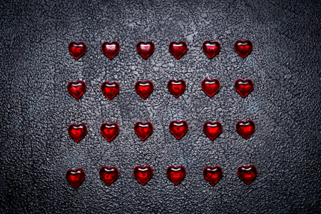 Rows of red hearts on a dark table. Concept of romantic loveの写真素材