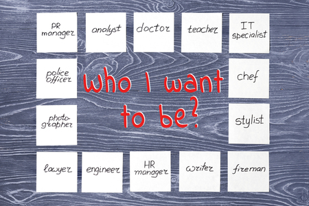 Stickers with different professions and inscription "Who I want to be?" on gray wooden background. Profession choosing conceptの写真素材