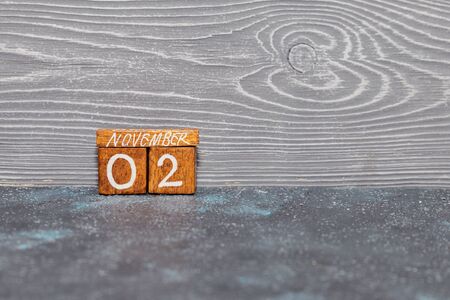 Old vintage wooden calendar representing November 2 on a gray background with copyspaceの写真素材
