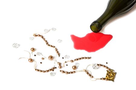 bottle with the poured out wine and torn beads on a white backgroundの写真素材