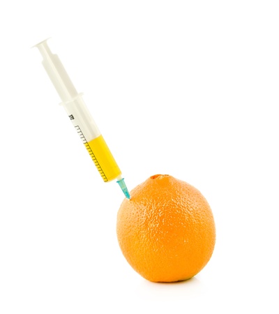  syringe is stuck in orange on a white backgroundの写真素材
