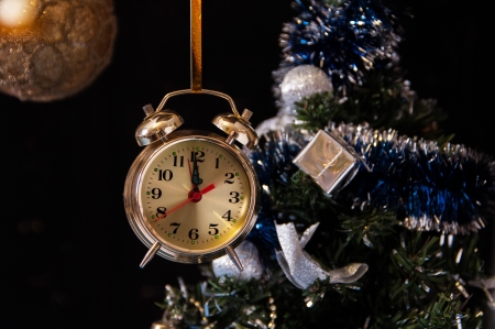 clock ,a decorated Christmas tree on a black background の写真素材