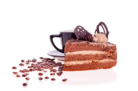 piece of cake on the background of a black Cup with saucer and scattered grain coffeeの写真素材