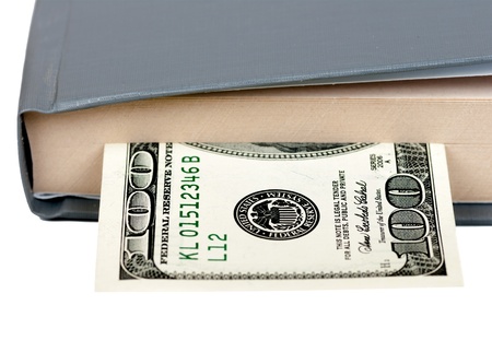 book is laid a hundred dollar bill on a white background