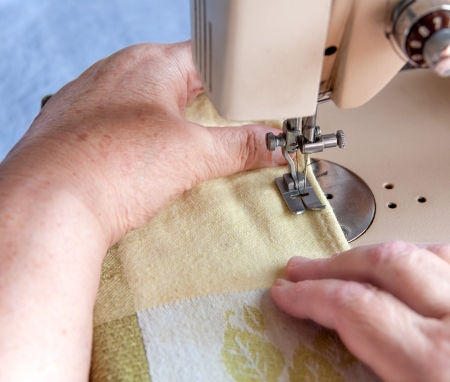 elderly woman sewing on the sewing machine