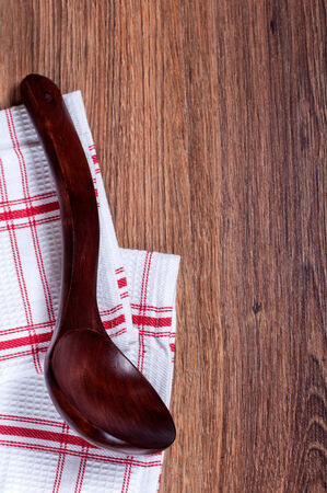 red wooden spoon on the white in the red cell towel and wooden backgroundの写真素材
