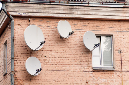 four satellite dishes on the front of the houseの写真素材