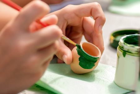 process of painting is a child of products from the clay potの写真素材