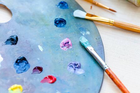 Brushes for painting dirty in paint lie on a palette with paintの写真素材