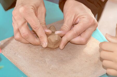  teacher shows the children how to make a ceramic whistle from the clay at the festival in Ukraine