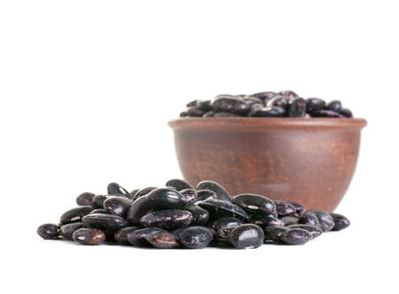 black beans, beans in a clay plate, isolated on white backgroundの写真素材