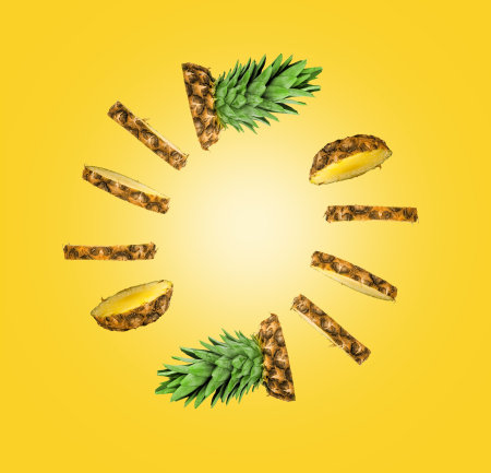 pineapple slices in the form of a circle, a circle of pineapple slices on a yellow backgroundの写真素材