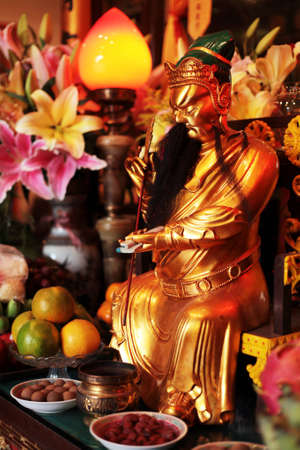 Buddhism. Altar of Chinese deity. Golden statuette.の写真素材