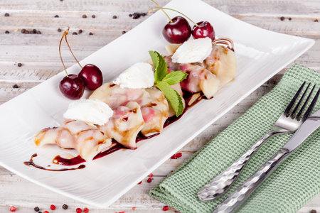 Russian dumplings with cherries on white tableの写真素材