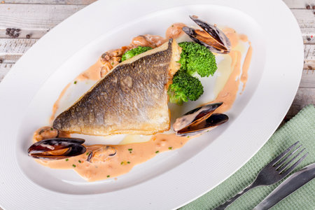 Fish fillet with seafood sauce on white plateの写真素材