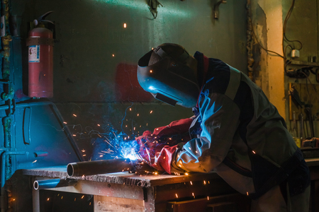 Metal welding worker in working process and fireの写真素材