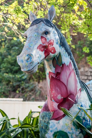 Art object on the street, painted horse close-up, with flowersの写真素材