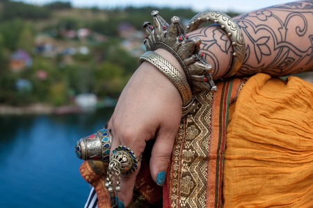 Tribal style jewelry on the hands of close-ups, iron rings and bracelets. Bright elements of decorating dancersの写真素材