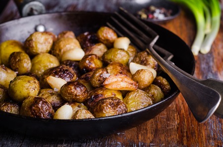 Roasted young potatoes in a pan with garlic and bacon.selective focusの写真素材