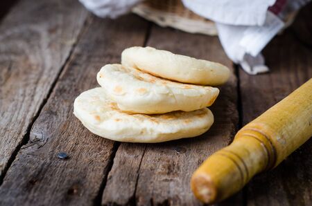 Freshly baked Moroccan bread mkhamer close up in a wooden bowl on the table. horizontalの写真素材