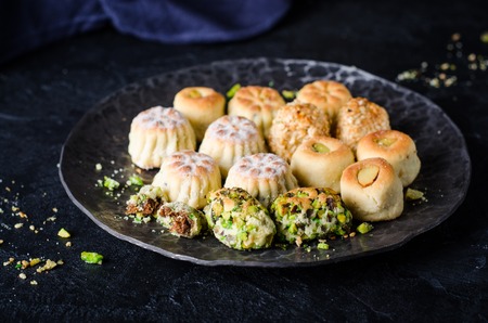 Maamoul or mamoul - arabic cookies stuffed dates with icing cugar on vintage wooden table background. Ramadan food. Arabian sweetsの写真素材