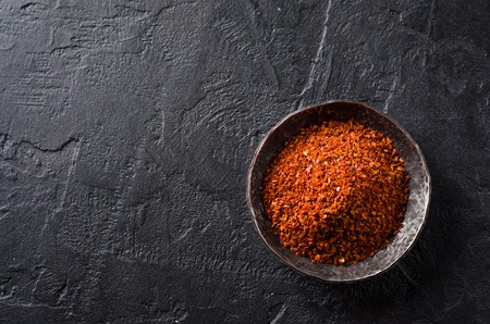 Crushed red chili pepper on dark stone