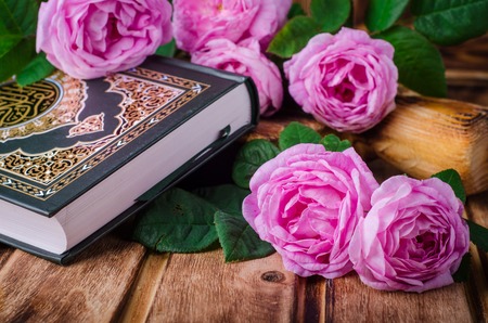 Quran with roses on wooden tableの写真素材