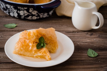 Homemade baklava stuffed cream with honey sirup on wooden table Eastern sweets. Ramadan food....