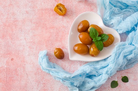 Raw fresh dates and green mint in a bowl on stone background. Selective focus. Ramadan food