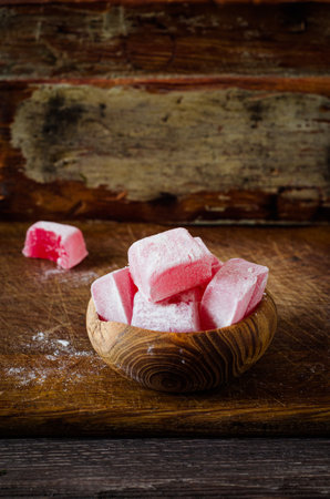 Rose flavored rahat lokum in bowl on wooden table.Turkish and arabian delight. Ramadan food. Selective focusの写真素材