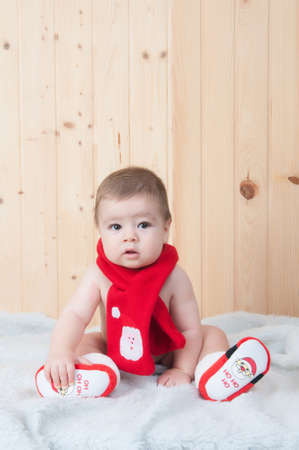 baby wearing santa claus clothes in a barnの写真素材