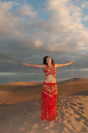 belly dancer in the desert at sunsetの写真素材