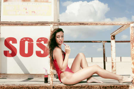 woman in swimsuit enjoying the sun in the life-saving booth