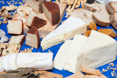 table set with a cheese board and different kinds of breadの写真素材