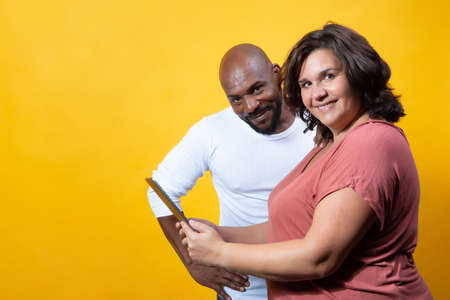 multiracial couple managing technology togetherの写真素材