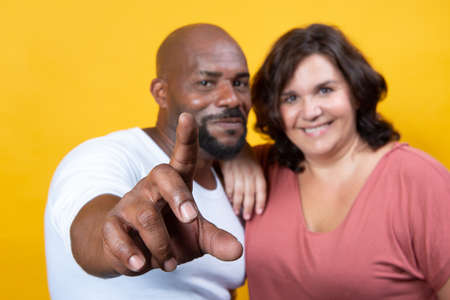 multiracial couple managing technology togetherの写真素材