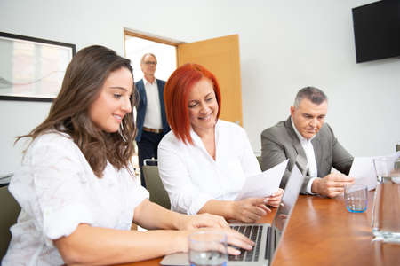 Business team of men and women in an office analyzing the evolution of the company