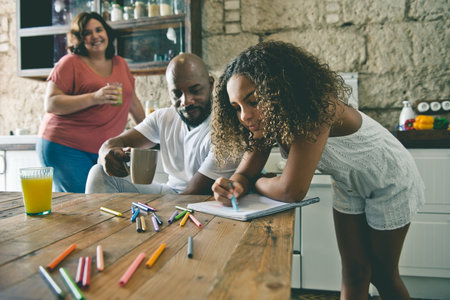 European and African American multiracial family in the kitchen of their home sharing momentsの写真素材