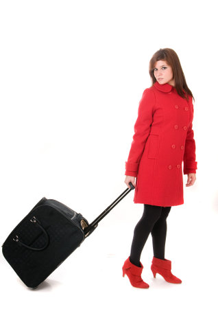 Attractive woman in red coat with bag or suitcase on white backgroundの写真素材
