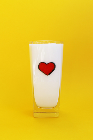 A glass of milk on yellow backgroundの写真素材