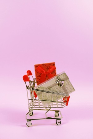 Online shopping concept. Shopping cart, small boxes, verticalの写真素材